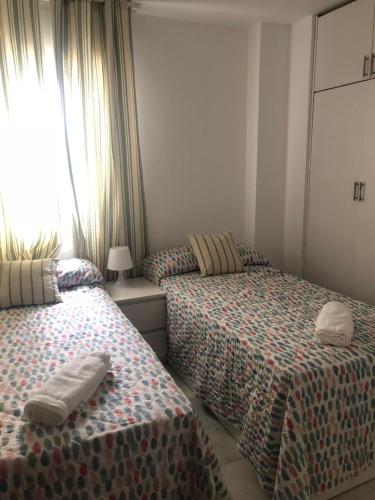 マラガにあるPiso Calle Miguel Bueno Lara 8 - Malagaのベッドルーム1室(ベッド2台、窓付)