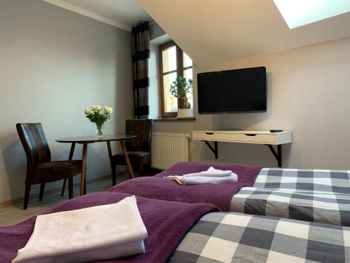 a bedroom with a bed and a tv on the wall at Arkada Wadowice in Wadowice