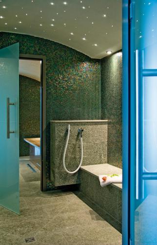 a bathroom with a shower and a bath tub at Hapimag Ferienwohnungen Hörnum in Hörnum