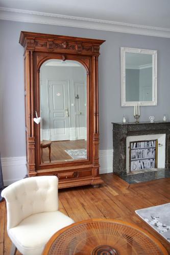 - un salon avec un grand miroir et une chaise dans l'établissement La Loge des Fées, à Latillé