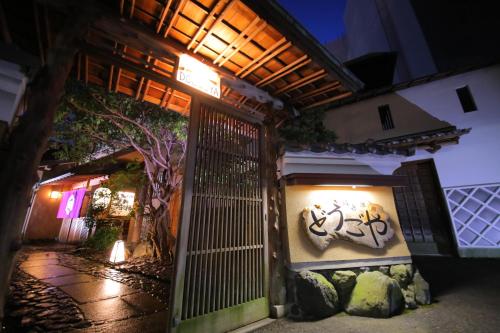 a gate to a building with graffiti on it at night at Dougoya in Matsuyama