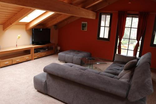 ein Wohnzimmer mit einem Sofa und einem Flachbild-TV in der Unterkunft Störitzland Betriebsgesellschaft mbH in Grünheide