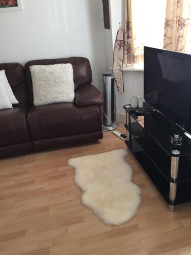 a living room with a couch and a television at Sturry House in Sturry