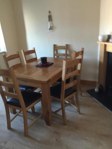 einen hölzernen Esstisch mit Stühlen und einem Tisch in der Unterkunft Sturry House in Sturry