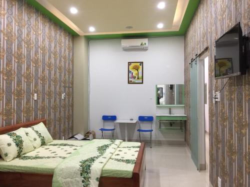 a bedroom with a bed and a table and chairs at Khách sạn Hương Sen Sa Đéc in Sa Ðéc
