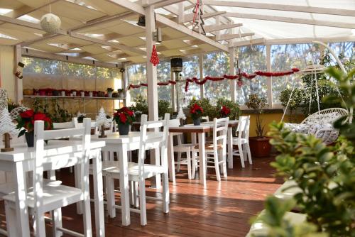 a dining room with white tables and white chairs at QuodLibet in Rome