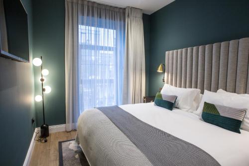 リムリックにあるThe Bedford Townhouseのベッドルーム1室(大きなベッド1台、大きな窓付)