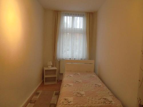 - une petite chambre avec un lit et une fenêtre dans l'établissement Ferienwohnung Rosenflair, à Schönebeck