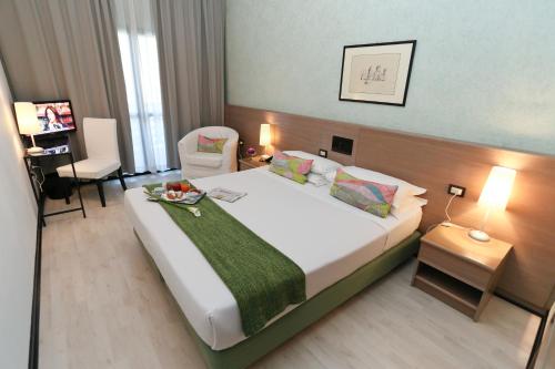 una habitación de hotel con una cama grande y una silla en Hotel Forum, en Sant'Ilario d'Enza