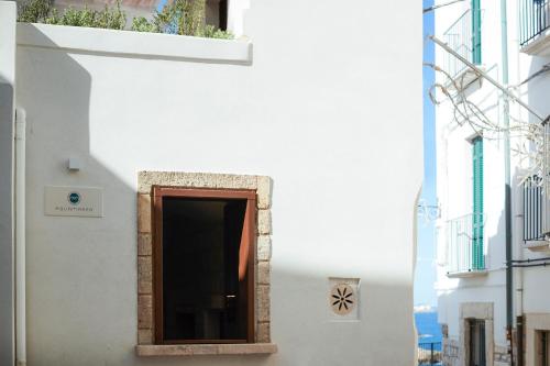 a door in a white building with a window at Aquamarea in Polignano a Mare