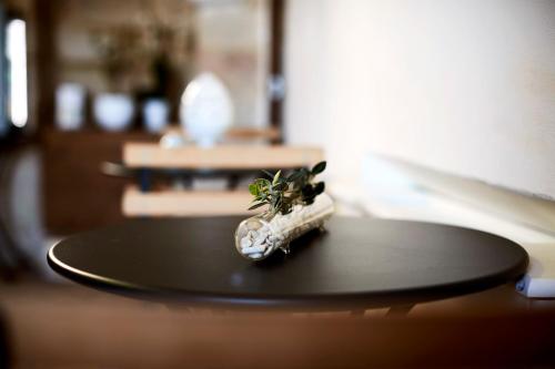 a small plant in a bottle sitting on a table at Aquamarea in Polignano a Mare
