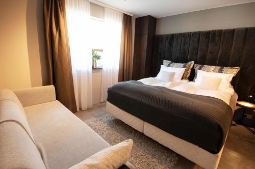 a bedroom with a large bed and a couch at Gardabær Sea View Apartment in Garðabær