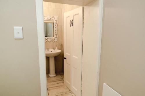 a white bathroom with a sink and a mirror at Point View Selfcatering in Mossel Bay