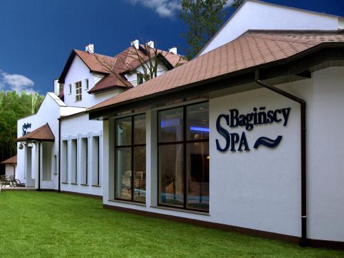 a white building with a sign on the side of it at Bagińscy Spa in Pobierowo