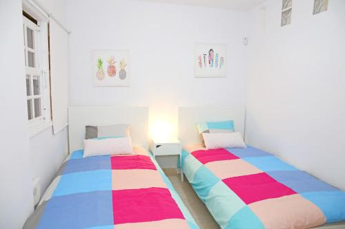 two beds in a white room with ainylinylinylinylinylinyl at Vivienda Vacacional Camino del Senderista in Lodero