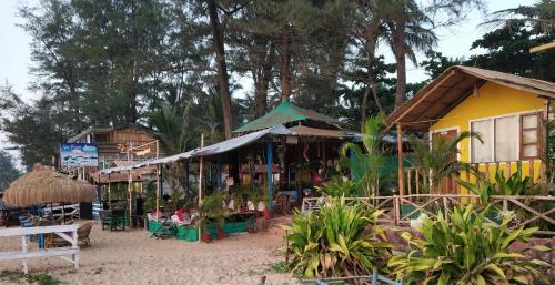 a group of shops in a village with trees at Sea Front Beach Huts in Patnem