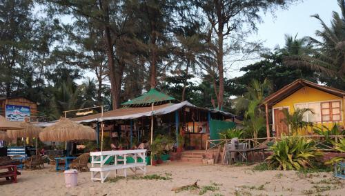 a store on the beach next to a building at Sea Front Beach Huts in Patnem