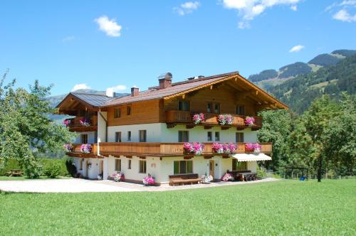 a large building with flowers on the side of it at Pension Ederhof in Jochberg