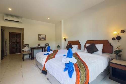two beds in a hotel room with blue fish on them at Kasemsuk Guesthouse SHA Extra plus in Karon Beach