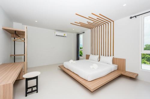 a bedroom with a bed and a desk and a window at Phuket Marine Poshtel - SHA Plus in Chalong 