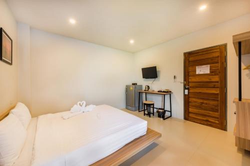 a bedroom with a bed and a desk and a television at Phuket Marine Poshtel - SHA Plus in Chalong 