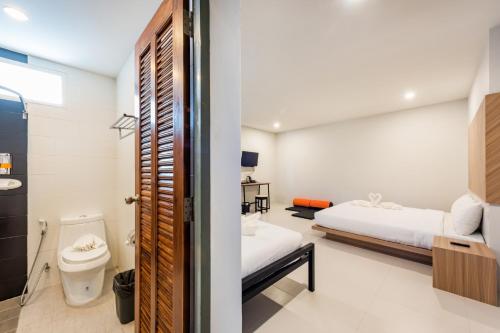 a bedroom with a bed and a toilet in a room at Phuket Marine Poshtel - SHA Plus in Chalong