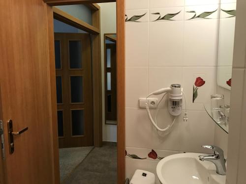 a bathroom with a sink and a phone on the wall at Antik Hotel Sofia in Litomyšl