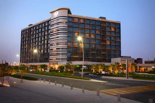a large building with a clock on top of it at Yas Island Rotana Abu Dhabi in Abu Dhabi
