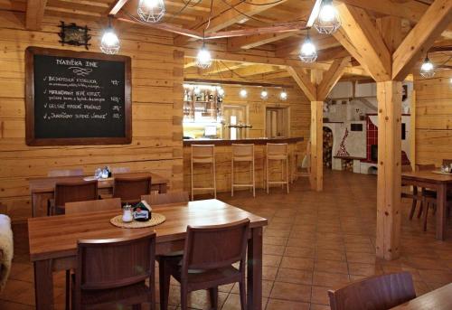 a restaurant with wooden tables and chairs and a bar at Penzion a restaurace Grunt in Řeka