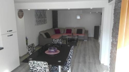 a living room with a table and a couch at APARTMAN SAUNA "NINO" in Gornje Jesenje