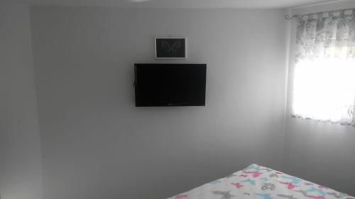 a bedroom with a flat screen tv on the wall at APARTMAN SAUNA "NINO" in Gornje Jesenje