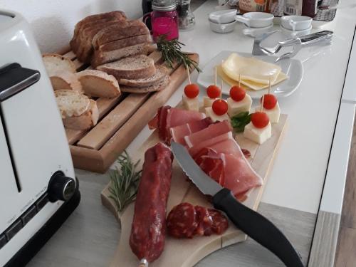 a table topped with meats and cheese and a knife at La Casa di Nina in La Maddalena