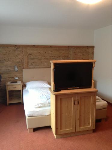 a bedroom with a bed with a flat screen tv at Villa Seceda in Selva di Val Gardena