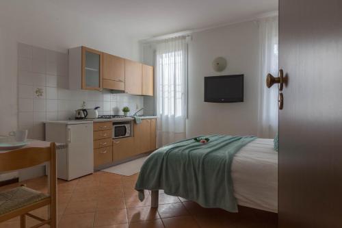 una pequeña cocina con una cama y una mesa en una habitación en La Rosa, en Ferrara