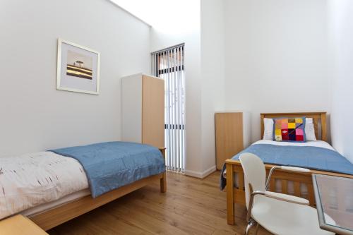 a bedroom with a bed and a desk and a chair at 6a Cedar Grove in Bangor
