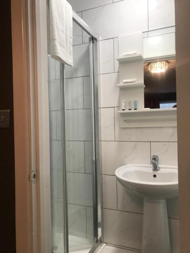 a white bathroom with a sink and a shower at Bede Apartments in Coventry