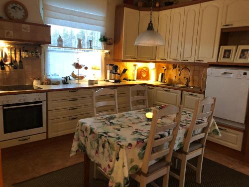 cocina con mesa y 2 sillas con mesa y cocina en Cozy house close to Arctic Circle, en Rovaniemi