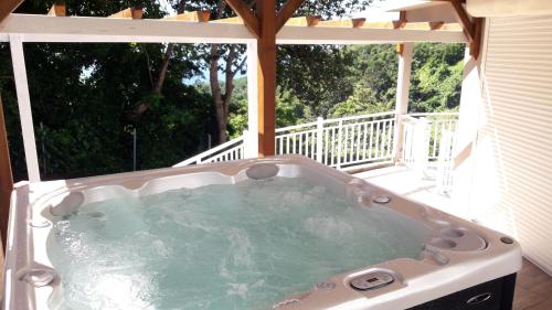 a jacuzzi tub on the deck of a house at L'Eden des Colibris in Vieux-Habitants