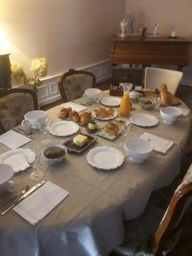 una mesa con platos y tazones de comida. en La Loge des Fées, en Latillé