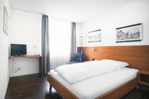 une chambre d'hôtel avec un lit et une télévision dans l'établissement Landgasthof Hotel Menzberg, à Menzberg