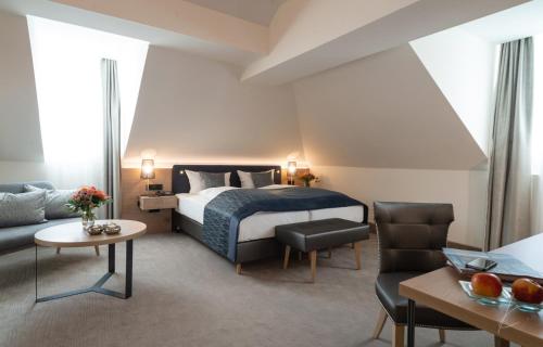 ベンドルフにあるRomantik Hotel Villa Saynのベッドとソファ付きのホテルルーム