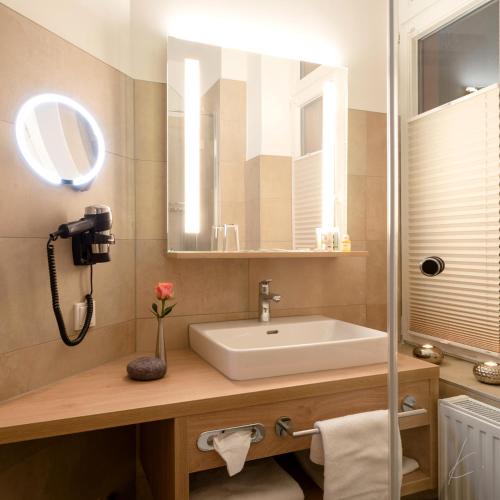 a bathroom with a sink and a mirror at Romantik Hotel Villa Sayn in Bendorf