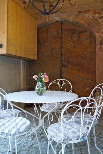 a white table and chairs with a vase of flowers at Gite de la Vieille Forge in Beblenheim