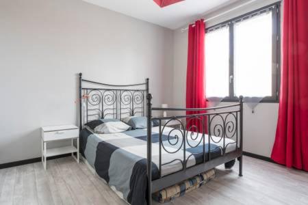 メーズにある13 rue de la pyramide Bel Appartementのベッドルーム1室(赤いカーテン付きの金属製ベッド1台付)