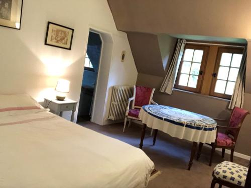 オーベルヴィルにあるMaison Normandeのベッドルーム1室(ベッド1台、テーブル、椅子付)