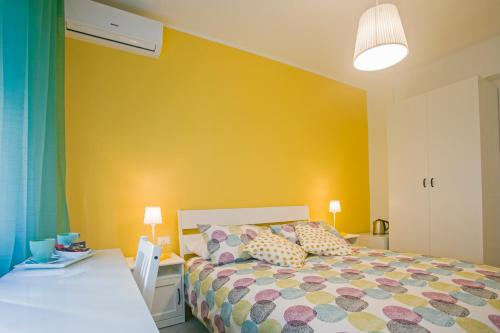 a bedroom with a bed and a yellow wall at B&B Sapore di Mare al Corso in Gaeta