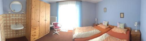 Schlafzimmer mit einem Bett, einem Waschbecken und einem Spiegel in der Unterkunft Ferienwohnung Ströbele in Badenweiler