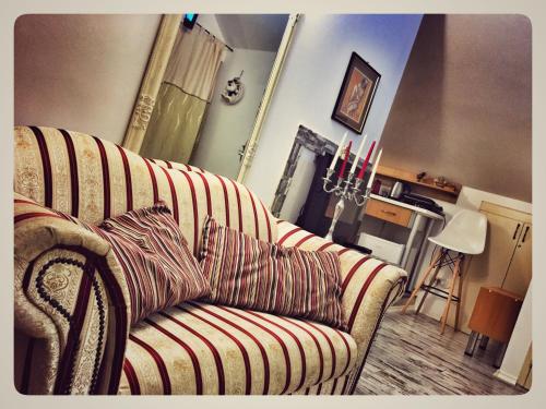 a living room with a striped couch and a fireplace at Eco Travel in Suceava