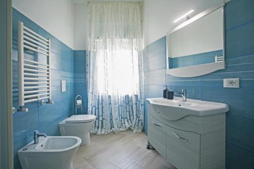 un bagno blu e bianco con lavandino e servizi igienici di B&B Sapore di Mare al Corso a Gaeta