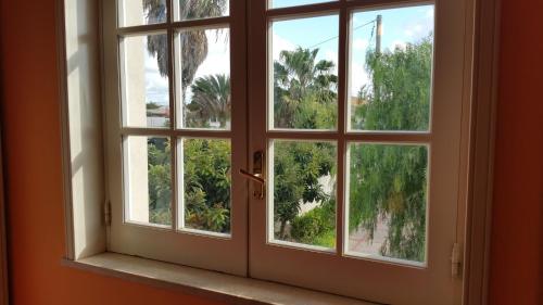 an open window with a view of palm trees at Anastasia Villas-B&B in Lido Signorino